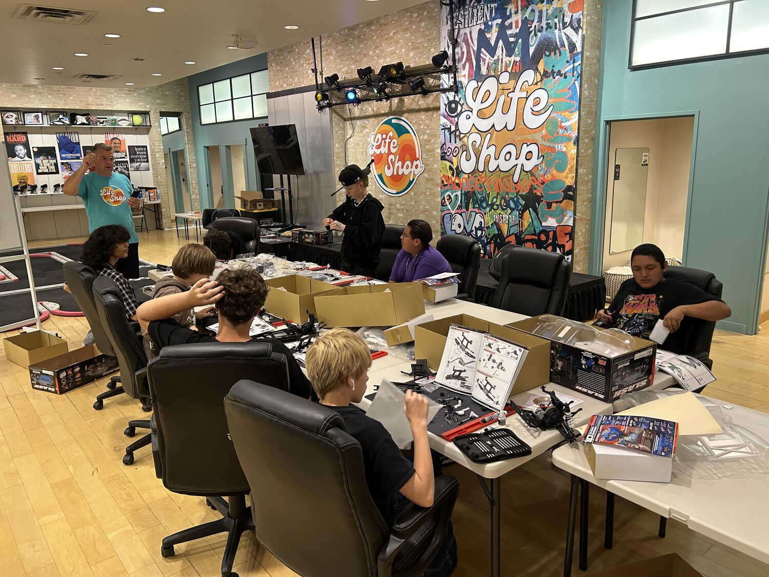 A Life Shop class in session: an instructor teaching while teens work through their build kits at the tables