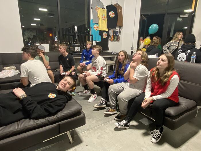 A group of teens on the couches at Life Shop, listening to the person leading the session