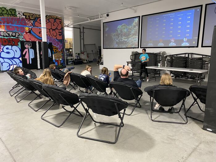 Teens in the moon chairs facing the screens during a class
