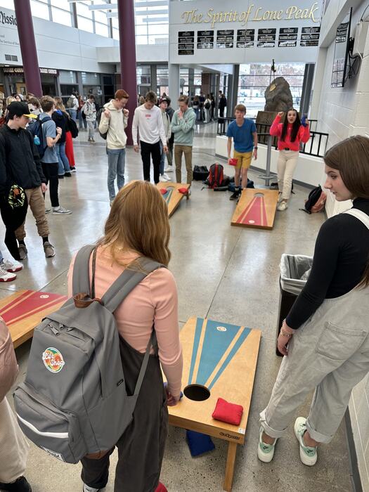 Students playing cornhole at a Life Shop school event