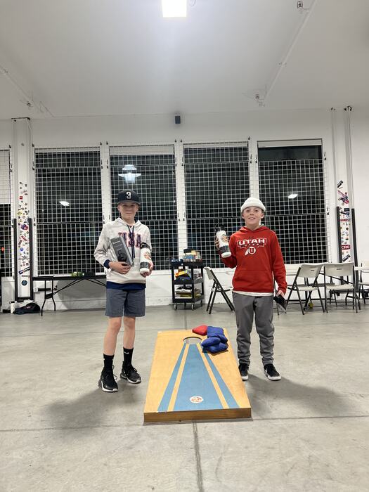 Cornhole winners holding up their Life Shop bottles
