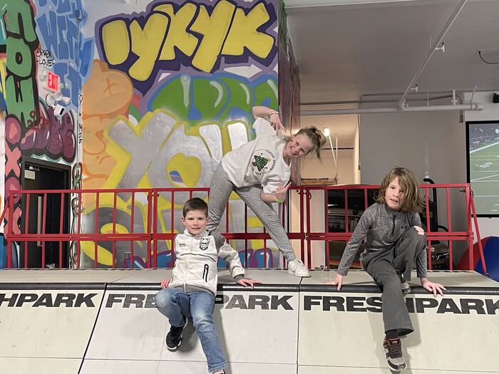 Teens in front of the IYKYK wall by the ramps