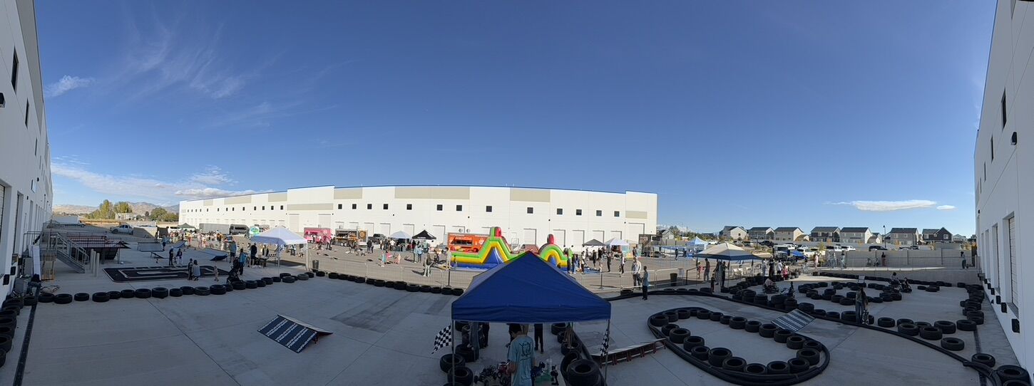 A panorama of a Life Shop outdoor event: ramp park, crazy cart circuit, food trucks and bounce houses