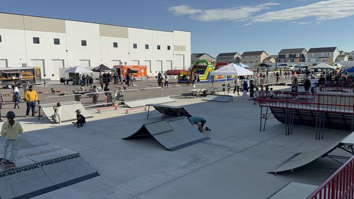 Dozens of kids riding the Life Shop mobile skate park at an outdoor event