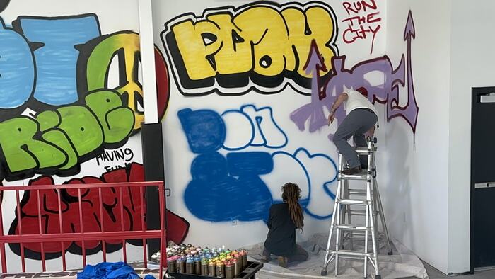The mural part-finished, an artist on a ladder