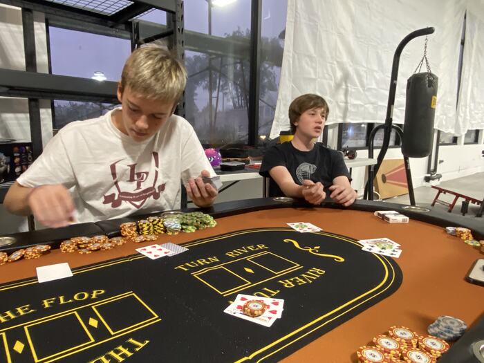 Teens deep in a hand at the Life Shop poker table