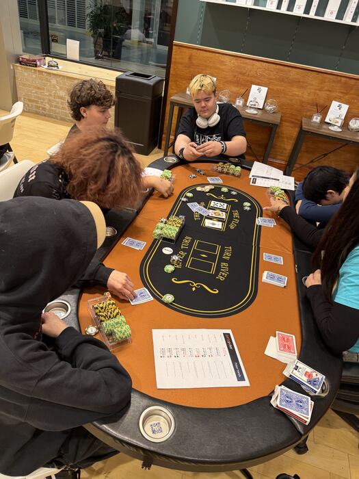A table of teens playing poker together on tournament night