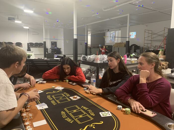 A full poker table of teens and staff