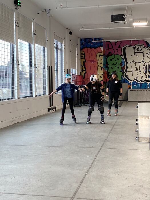 Teens rollerblading across the main room