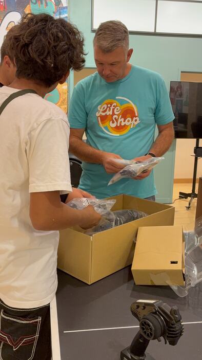 A teen and a staff member unboxing new kit