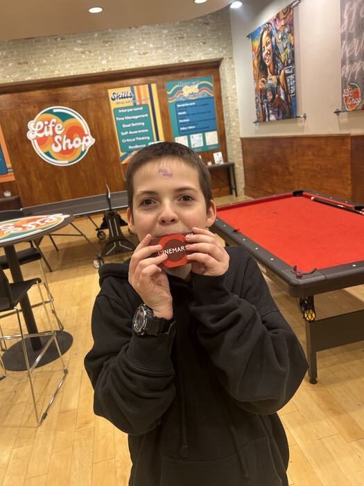 A teen holding up a finished RC car
