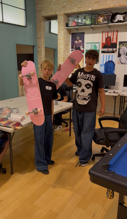 Two teens holding Life Shop skate decks