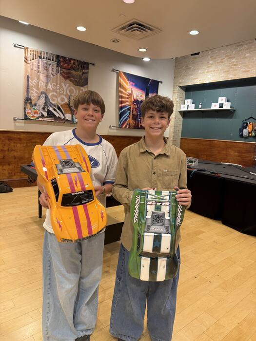 Two teens holding RC bodies they painted themselves