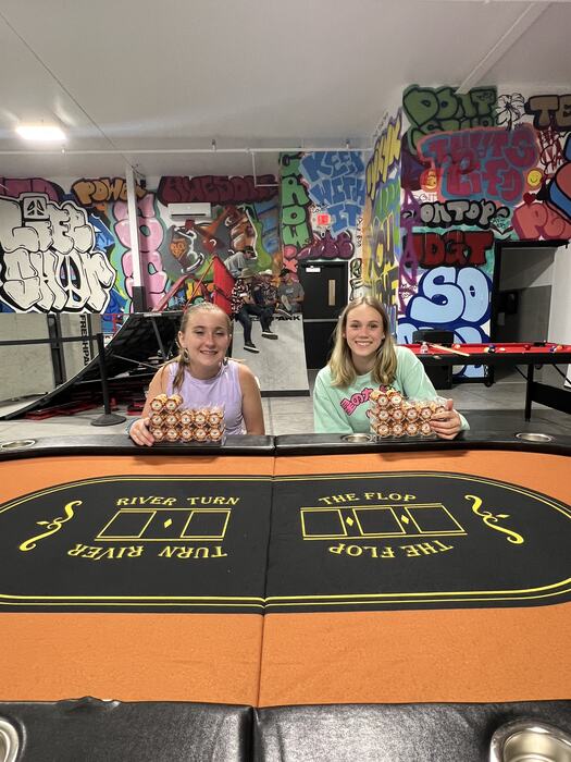 Two teens at the poker table with their chips
