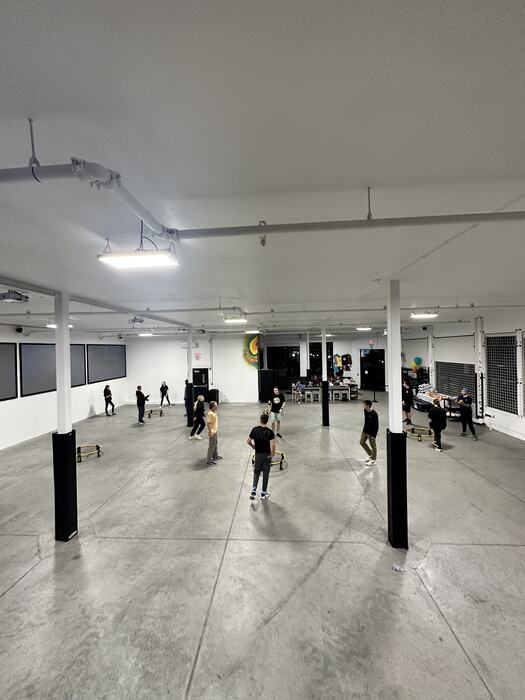 Teens playing volleyball over a ribbon strung across the room