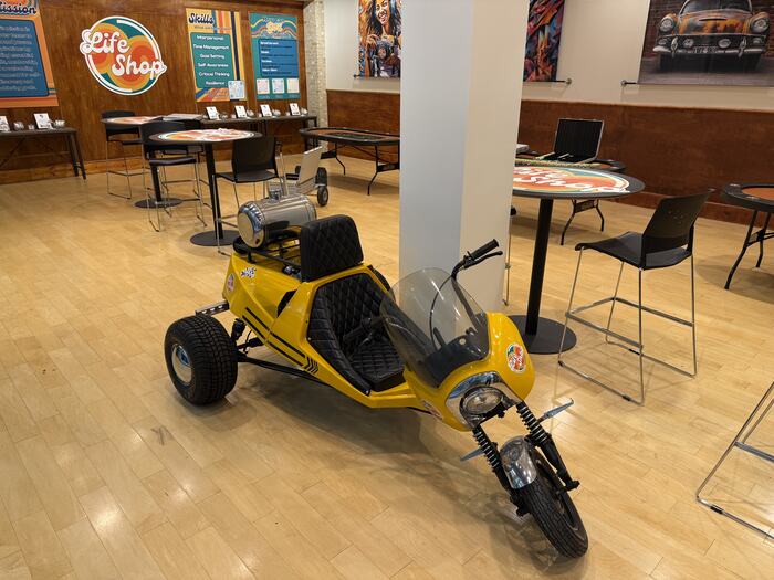 The yellow three-wheeler built at Life Shop